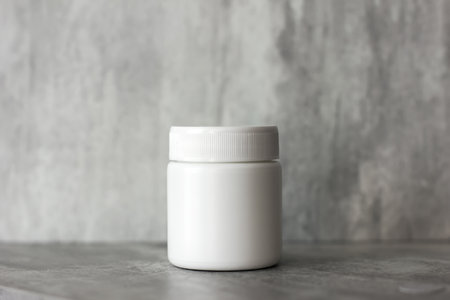 empty cosmetic plastic white cream jar. Gray background. container for cosmetics. Cosmetic concept. minimalistic photoの写真素材