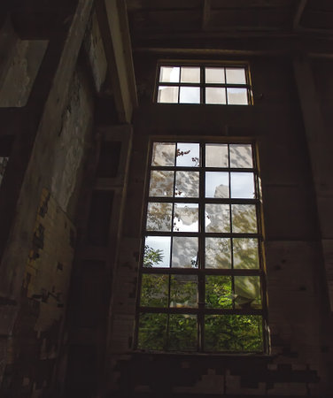A large broken window in an old destroyed building. Old ruined haunted house, abandoned house. The lost city of Pripyat. Chernobyl - imageの写真素材