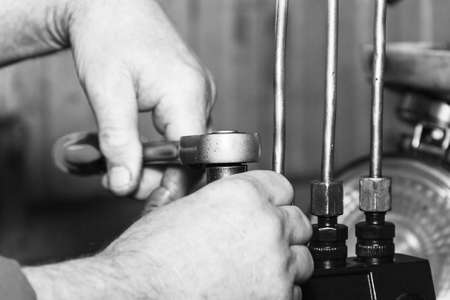 Professional mechanics testing diesel injector in his workshop, repair of diesel fuel injectors, ustroustvo for the diagnosis of fuel injectors soft focusの写真素材