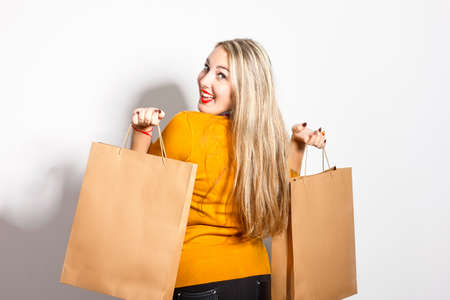 beautiful woman with shopping bags in a shopping rejoicing on a white background in studio