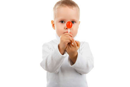 happy baby boy eating candy Lollipop, on white background, focus on candyの写真素材