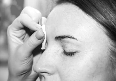 Correction of eyebrow tweezers, eyebrow henna painting, beautiful young girl beauty salon, plucking and simulation form a perfect eyebrows, tattoos and permanent make-up, very soft focusの写真素材
