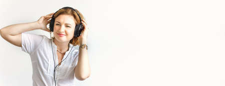 Beautiful girl in headphones, soft focus, on white backgroundの写真素材