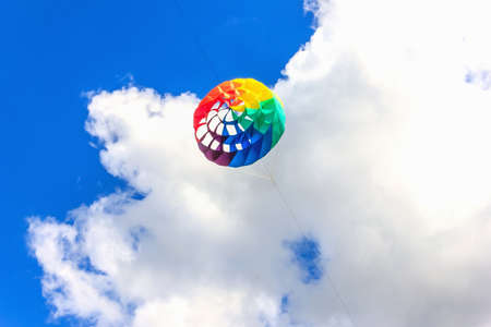 Colorful kite free to fly in the clear sky, a beautiful summer dayの写真素材