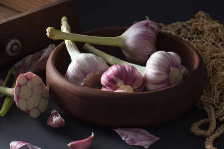 Fresh garlic. Kind of garlic in a clay plate sitting against a dark background. Mill food. Harvest Food stock photography. Healthy food. food photography - Imageの写真素材