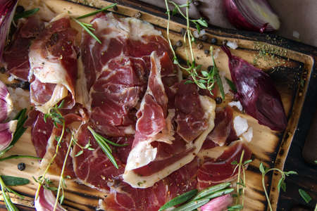 Hamon.Tasty ham sliced â€‹â€‹into strips on a wooden background with spices and fresh...