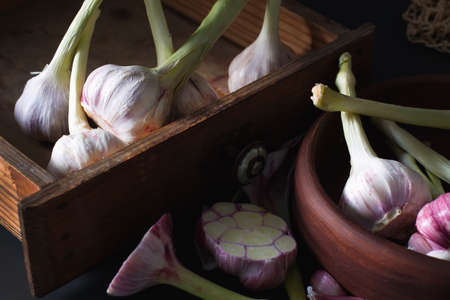 fresh garlic. Kind of garlic in a small vintage box sitting on a dark background. Mill food. Harvest food stock photography. Health food. food photographyの写真素材