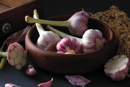 Fresh garlic. Kind of garlic in a clay plate sitting against a dark background. Mill food. Harvest Food stock photography. Healthy food. food photography - Imageの写真素材