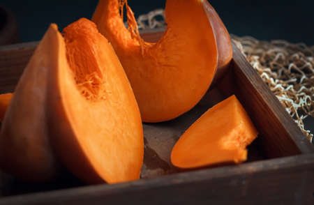 Fresh juicy pumpkin. Sliced ââraw orange pumpkin in a vintage wooden pulp on a table against a dark background. Mill food. ... Food stock photography. Healthy food. food photography - Imageの写真素材