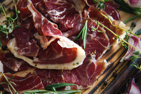 Hamon.Tasty ham sliced ââinto strips on a wooden background with spices and fresh thyme. A serving of lean pork. meat product. Food Photography - Image. View from aboveの写真素材