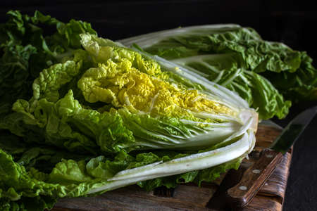 Fresh Chinese cabbage in a cut on a dark wooden background. Diet nutrition. Vegetables and fruits. Dark Food Photographyの写真素材