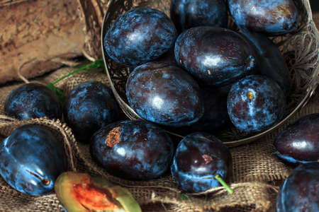 Garden plums on the table. Autumn harvest. Blue plums. Fresh plums on a wooden surface. Fresh plums on a wooden table background. Food Photo - Imageの写真素材