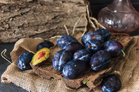 Garden plums on the table. Autumn harvest. Blue plums. Fresh plums on a wooden surface. Fresh plums on a wooden table background. Food Photo - Imageの写真素材