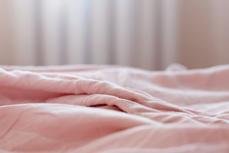 view of the morning crumpled bed in the hotel room. in the morning light. Cozy morning atmosphere. unmade bedding for sleeping. Shallow depth of field. selective focus. color 2022の写真素材