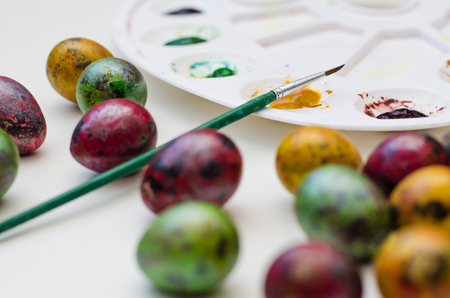 easter still life with colored eggs, palette and paintbrushの写真素材