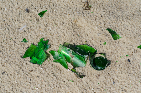 shard bottle among the shells on the sandy beachの写真素材