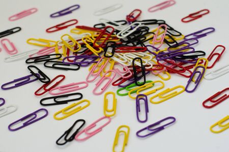 a bunch of colorful paper clips on white paperの写真素材