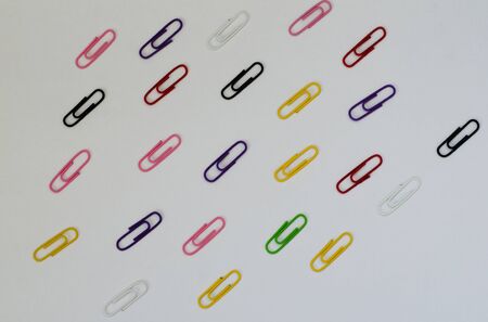 a lot of colorful paper clips on white paperの写真素材