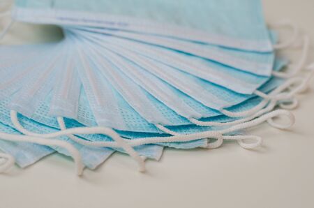 a lot of medical surgical masks on a white background. protection against corona virus. stay home