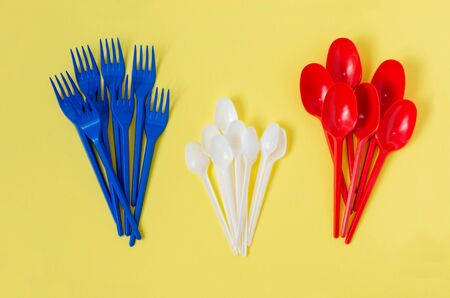 disposable plastic colored dishes on a yellow background, top viewの写真素材