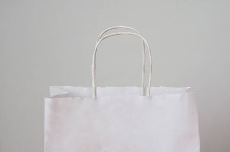 white paper bag with handles for shopping on a white backgroundの写真素材