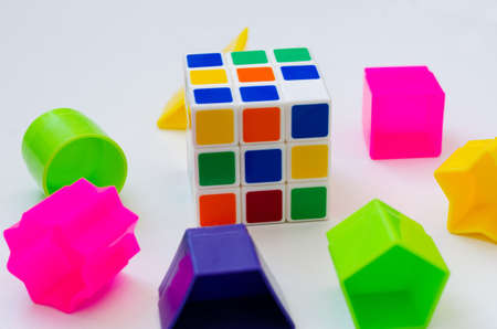 rubik's cube and different game color pieces on a white backgroundのeditorial素材