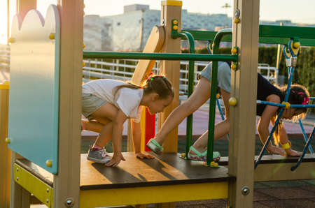 children climb on all fours on the rope bridge in the playgroundの写真素材