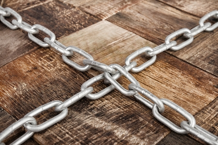 Steel chain on wooden background. Macro shot.の写真素材
