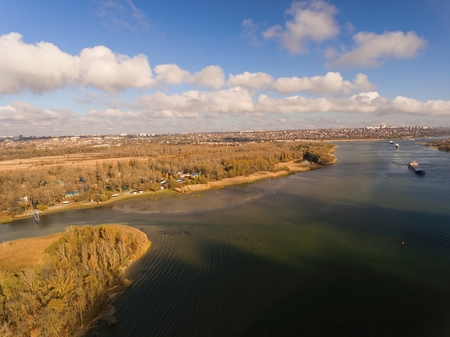 Cargo ship in beautiful river. Aerial view. Autumn landscape.