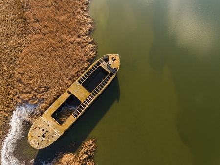 Abandoned broken ship in autumn river. Aerial view.の写真素材