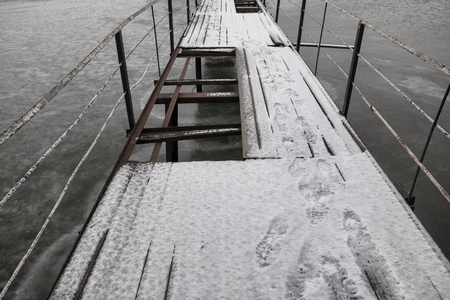 Frozen old pier at river side in winter time.の写真素材
