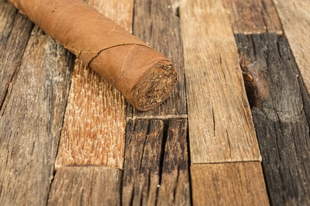 Brown cigar on wooden background. Macro shot.の写真素材
