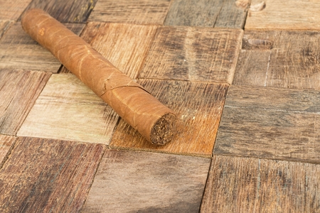 Brown cigar on wooden background. Macro shot.の写真素材