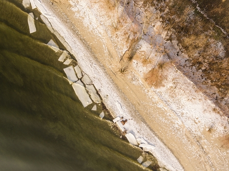 Frozen river. Riverside in winter time. Aerial view.