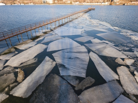 Frozen old pier at river side in winter time. Aerial view.の写真素材