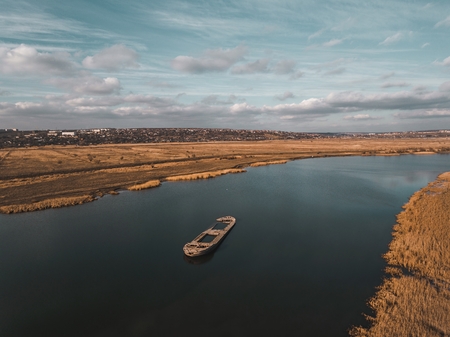Abandoned broken ship in autumn river. Aerial view.の写真素材