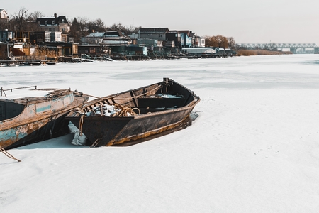 Old fishing boat frozen in the ice in river. Stock image.の写真素材