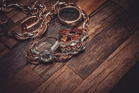 Beautiful golden jewelry on wooden background. Macro shot.