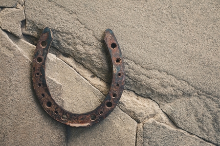 Old rusty horseshoe on natural stone background. Macro shot.の写真素材