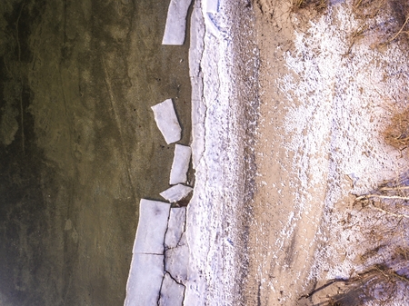 Ice floating on river in spring time. Winter landscape with melting of ice floe. Aerial view.