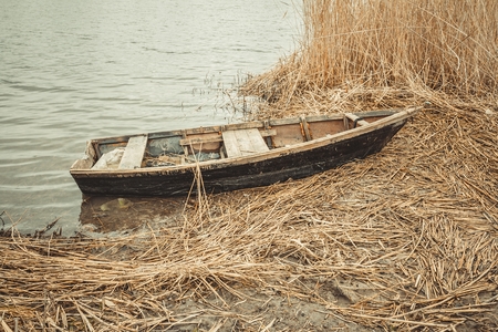 Old boat on the river bank in spring time.の写真素材
