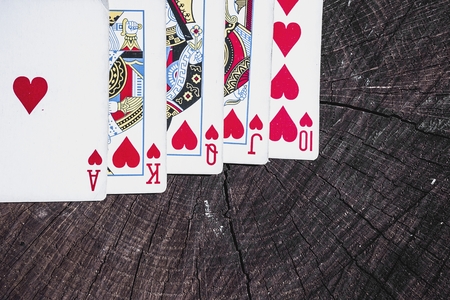 Playing cards on wooden surface. Royal flush.