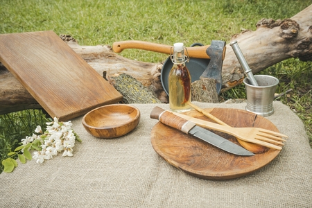 Rustic cooking utensils. Wooden spoon, ax, bowl, knife and cutting board.
