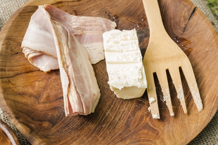 Bacon strips and butter in wooden bowl with cooking utensils. Stock image.の写真素材