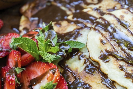 Homemade pancakes with, juicy strawberry, fresh mint and chocolate. Natural healthy food concept.の写真素材