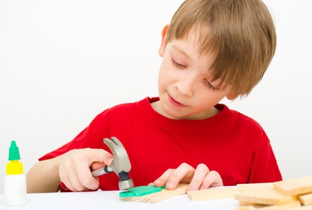 Cute boy working with hammer and nail