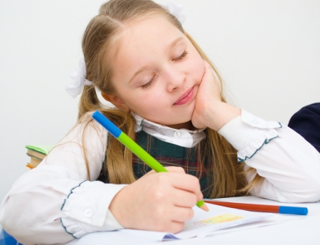 Closeup portrait of a schoolgirl drawing with colorful pencilsの写真素材