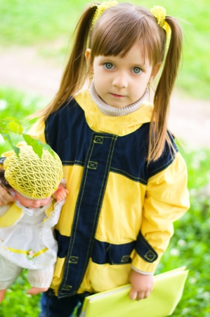 girl with book and doll at the parkの写真素材