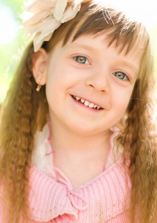 closeup portrait of a little happy girl outdoorsの写真素材