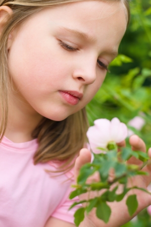 closeup portrait of a little cute girl with flower outdoorsの写真素材